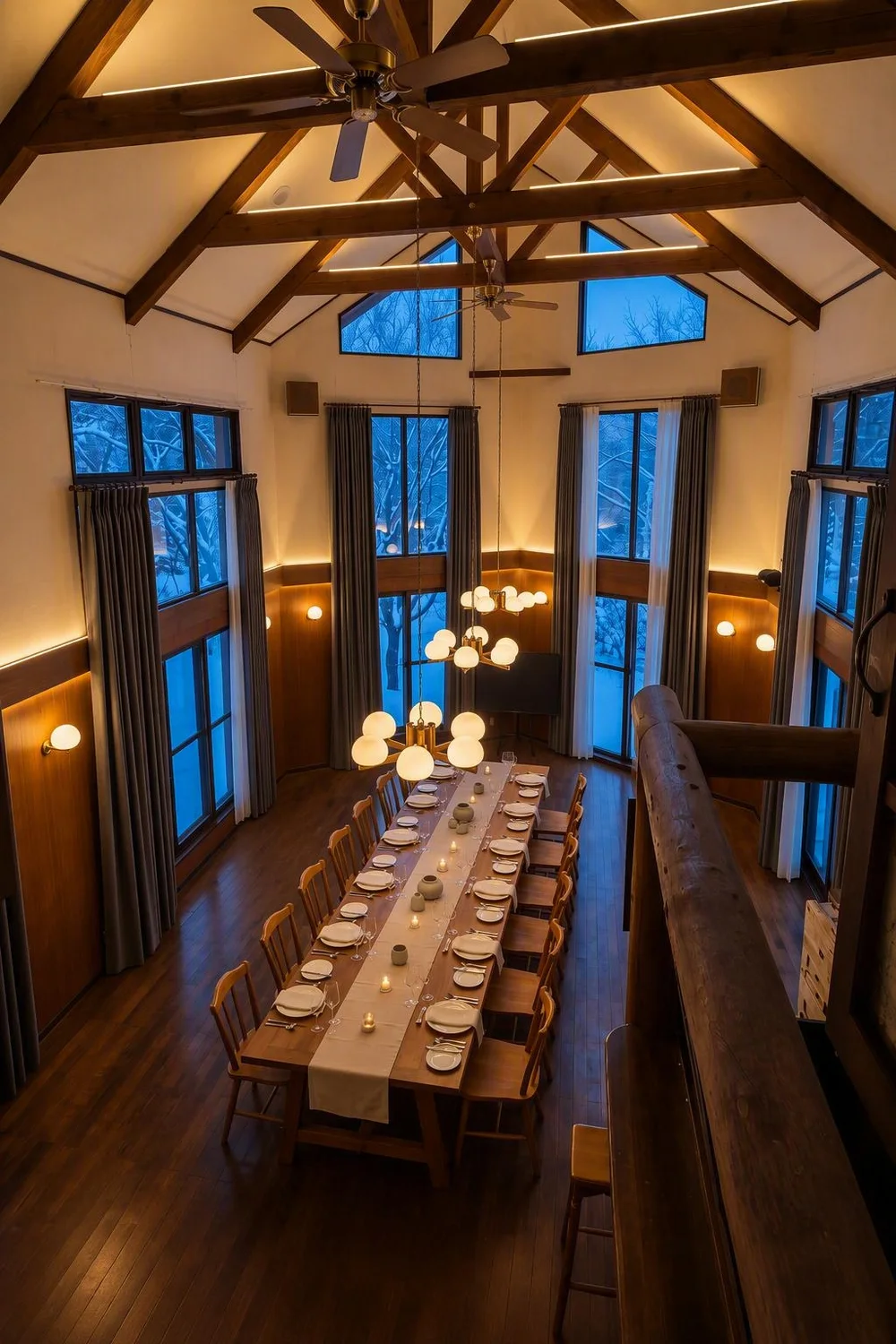The Table at Konamori from the balcony: one long table set for dinner, candles lit, snow through the tall windows